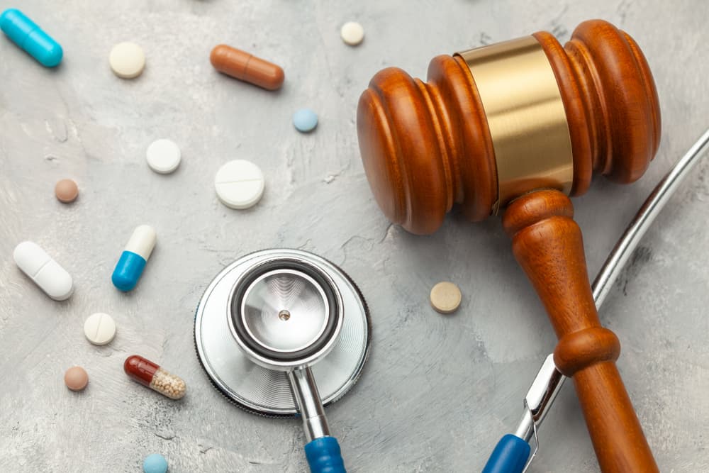 Judge gavel and stethoscope with pills symbolizing the intersection of law and medicine, potentially regarding medical negligence.