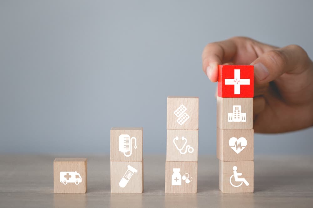 Healthcare Icons: Arranging wood blocks, symbolizing health insurance and medical concepts.
