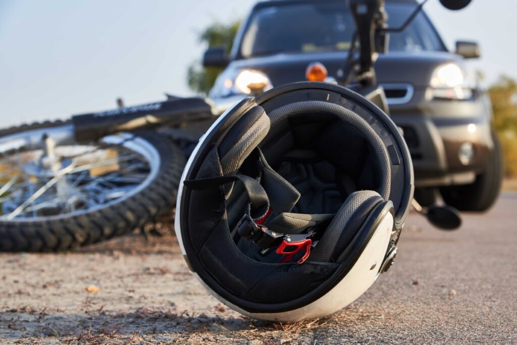 Motorcycle helmet on road after motorcycle accident with car, showing crash scene and traffic collision.
