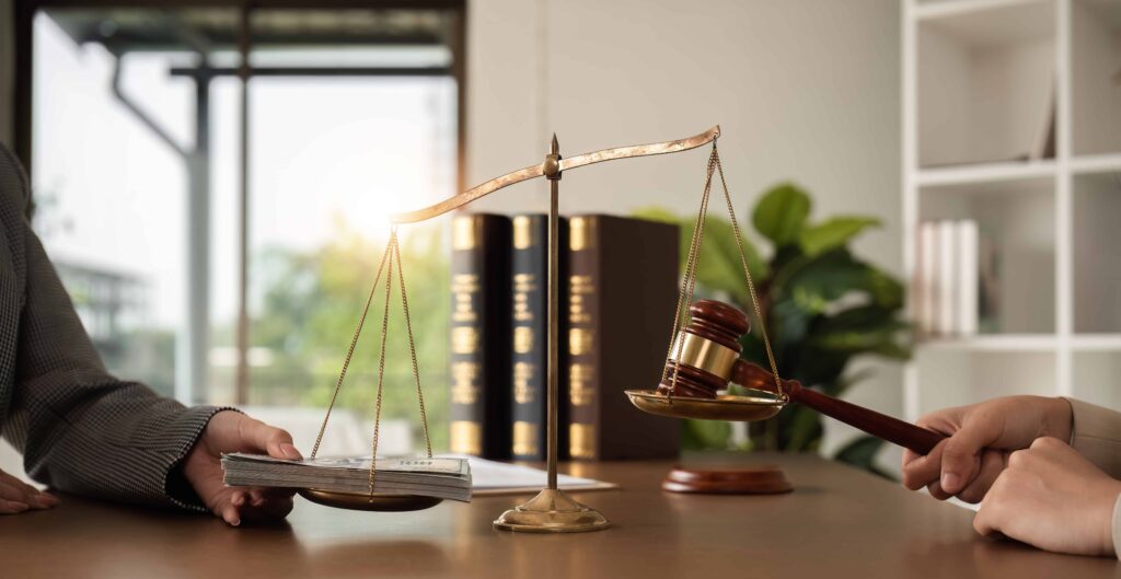 Scales of justice balancing cash and a judge&rsquo;s gavel, symbolizing legal settlements and financial justice